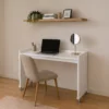Compact mobile bedroom desk on wheels positioned against wall